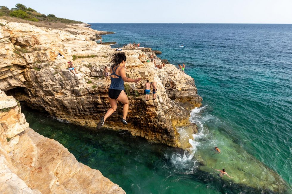 sanjam skok sa stijene u modrozeleno more